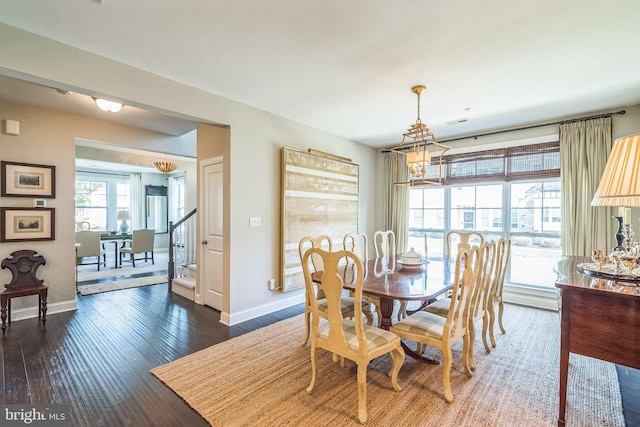 dining area with baseboards, dark wood finished floors, a chandelier, and visible vents