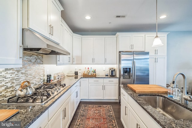 kitchen with pendant lighting, appliances with stainless steel finishes, a sink, white cabinets, and under cabinet range hood