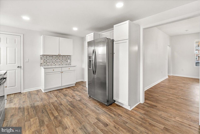 kitchen featuring stainless steel fridge, recessed lighting, wood finished floors, and white cabinets