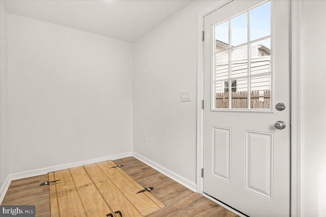 entryway featuring baseboards and wood finished floors