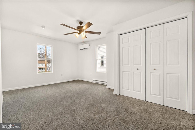 unfurnished bedroom with dark colored carpet, multiple windows, baseboard heating, and a wall mounted air conditioner