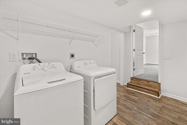 laundry area featuring laundry area, visible vents, wood finished floors, baseboards, and washing machine and clothes dryer