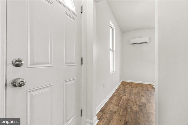 corridor with baseboards, a wall unit AC, and dark wood-style floors