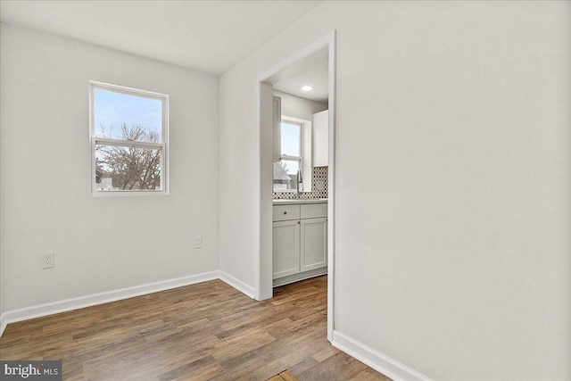 unfurnished room with baseboards, recessed lighting, and wood finished floors