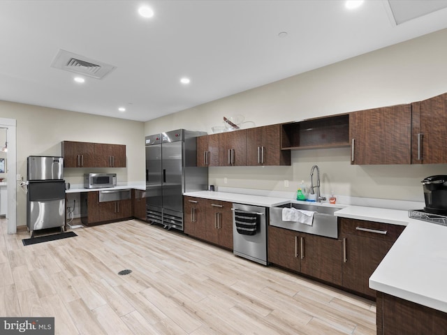20515 Anchor Ln, Frankford, DE 19945 - kitchen featuring visible vents, dark brown cabinets, light countertops, a sink, and appliances with stainless steel finishes