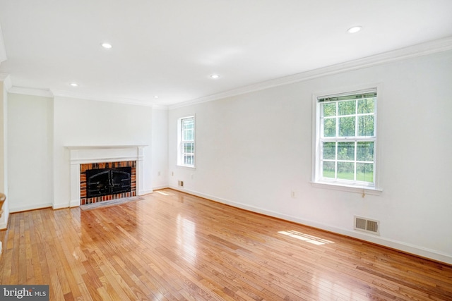 unfurnished living room with crown molding, light wood finished floors, and visible vents