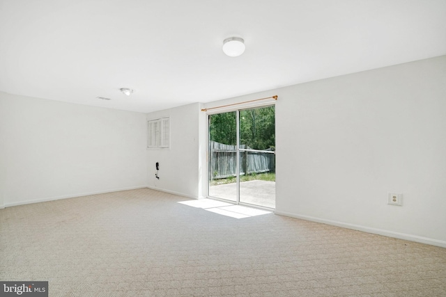 carpeted spare room featuring baseboards
