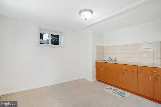 bar featuring a sink, baseboards, decorative backsplash, and light colored carpet