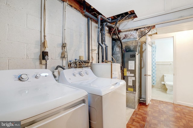 laundry room featuring concrete block wall, laundry area, and washing machine and clothes dryer