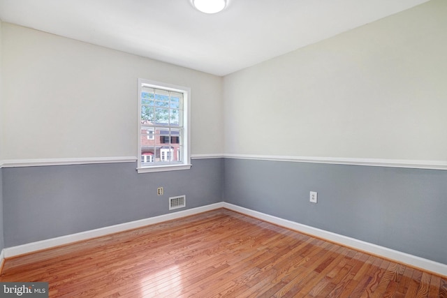spare room featuring visible vents, baseboards, and light wood-type flooring