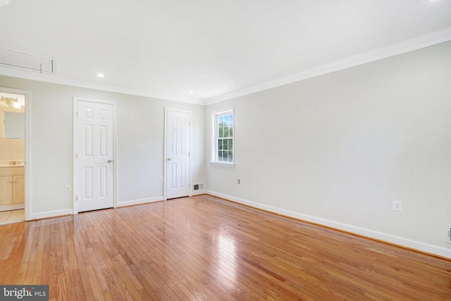 unfurnished bedroom with visible vents, ornamental molding, baseboards, and light wood-type flooring