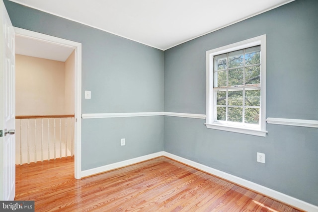 unfurnished room with baseboards and wood finished floors