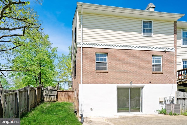 9239 Sand Creek Ct, Burke, VA 22015 - back of property with fence, central AC unit, a chimney, and brick siding