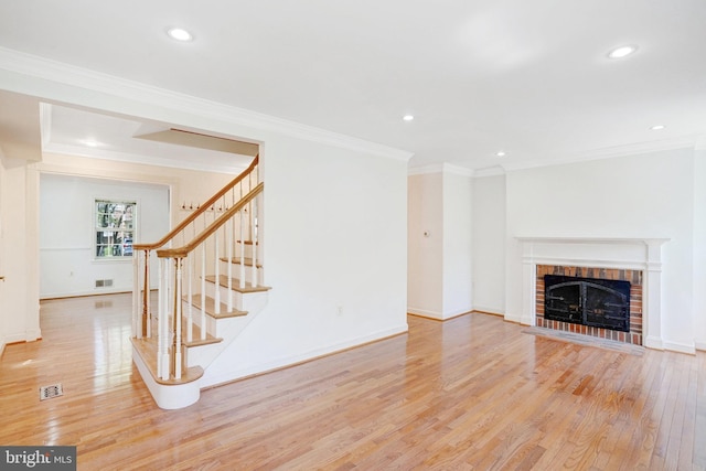 unfurnished living room featuring stairs, recessed lighting, crown molding, and light wood-style flooring
