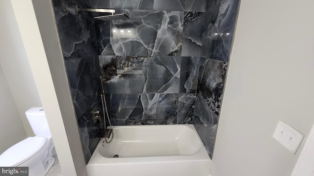bathroom with bathing tub / shower combination and toilet