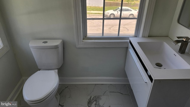 bathroom with vanity, baseboards, toilet, and marble finish floor