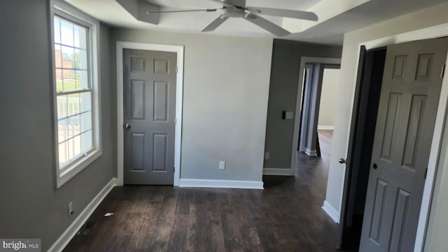 unfurnished bedroom featuring baseboards and dark wood-style floors