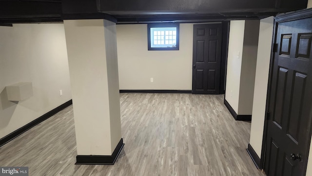 basement featuring baseboards and wood finished floors