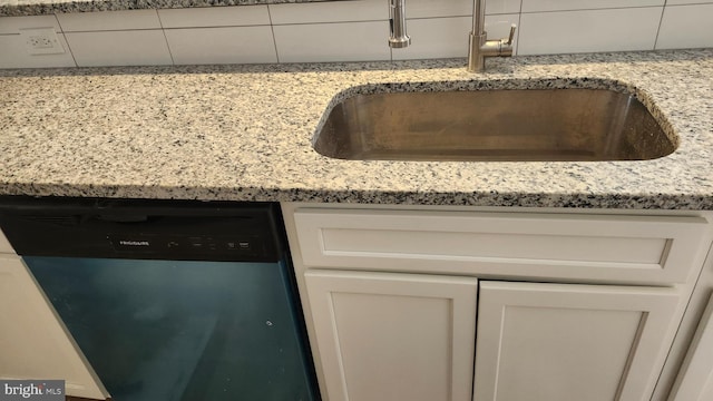 room details with a sink, light stone counters, white cabinetry, and dishwasher