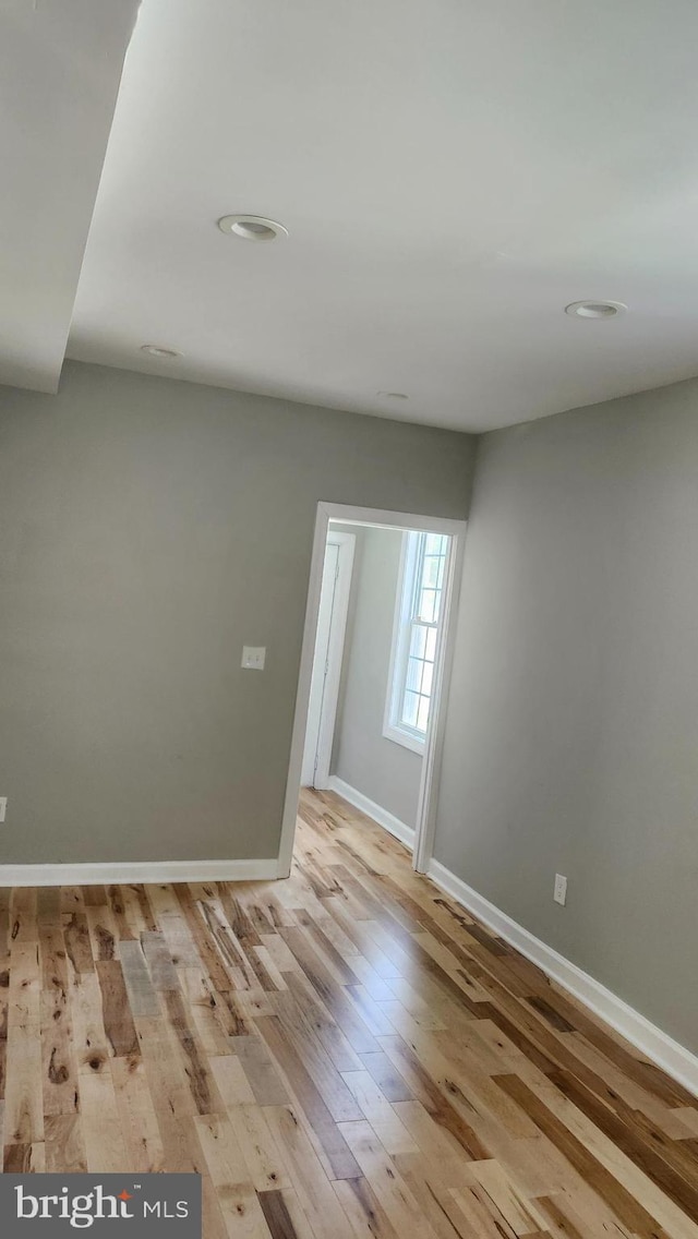 unfurnished room with baseboards, wood-type flooring, and recessed lighting