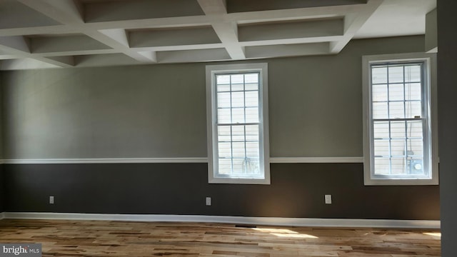 spare room with baseboards, beam ceiling, coffered ceiling, and wood finished floors