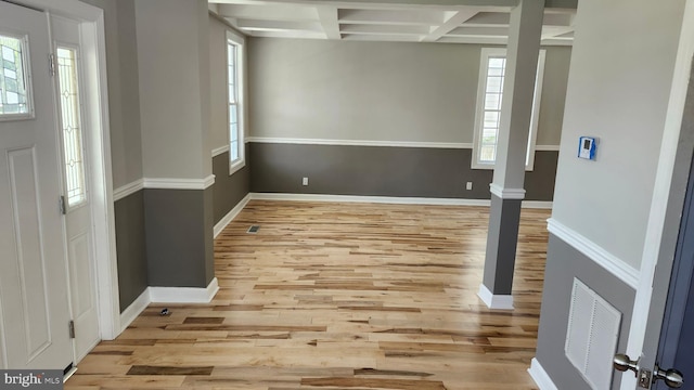 entryway with baseboards, coffered ceiling, wood finished floors, and visible vents