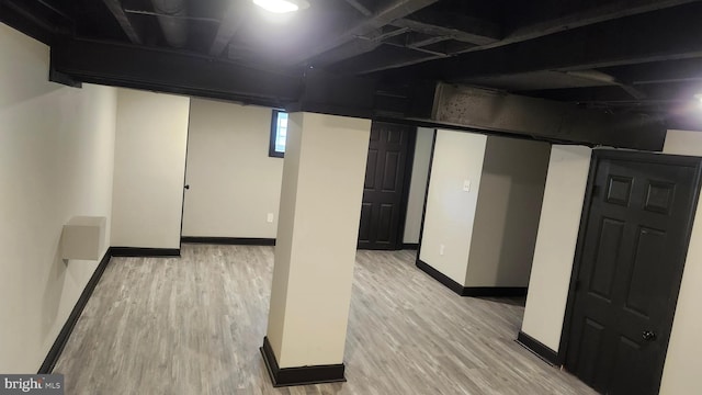 basement featuring baseboards and light wood-type flooring