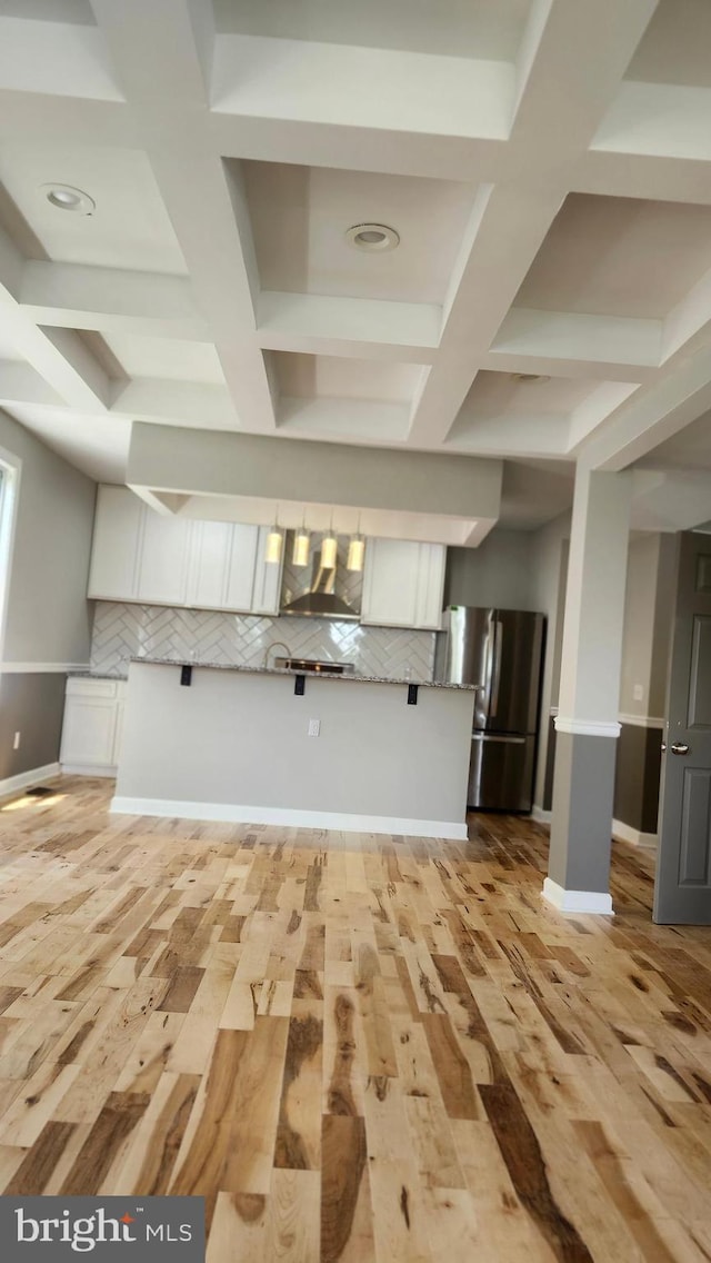 kitchen with freestanding refrigerator, tasteful backsplash, wall chimney exhaust hood, and coffered ceiling