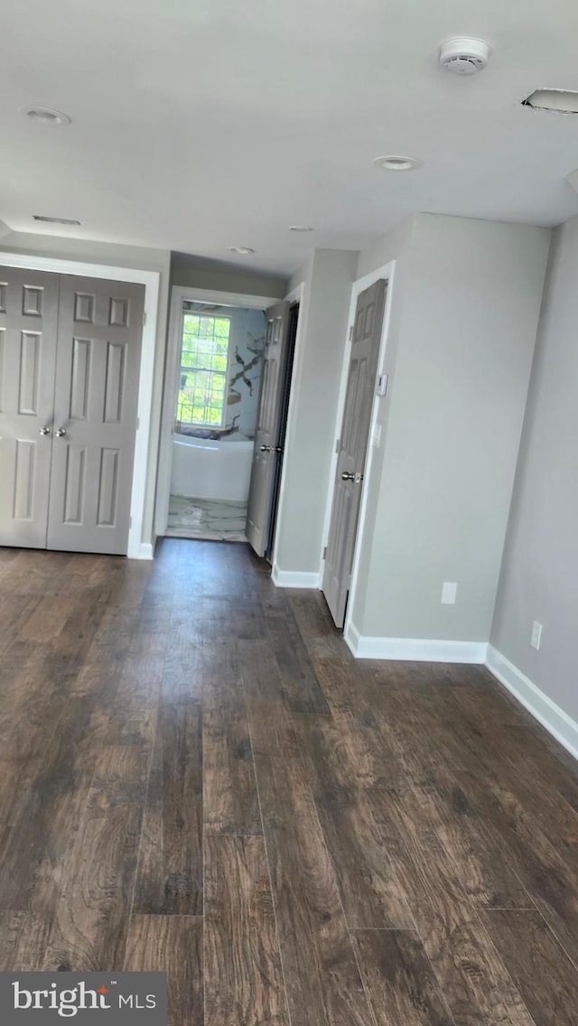 foyer with baseboards and dark wood finished floors
