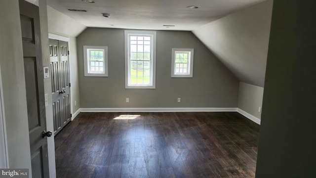 bonus room featuring baseboards, dark wood-style floors, and lofted ceiling