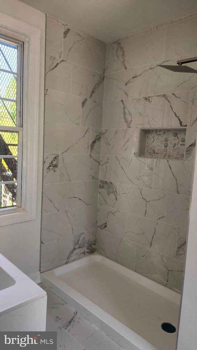bathroom with a tub, walk in shower, and marble finish floor