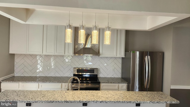 kitchen with wall chimney range hood, backsplash, light stone countertops, and appliances with stainless steel finishes