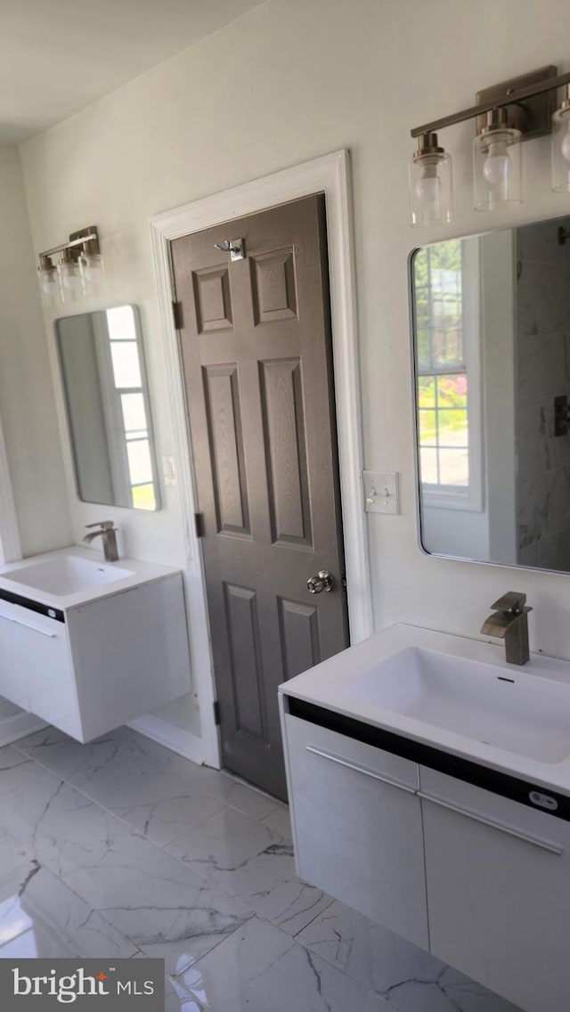 full bathroom with two vanities, a sink, and marble finish floor