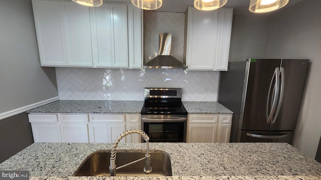 kitchen with a sink, appliances with stainless steel finishes, backsplash, and wall chimney range hood