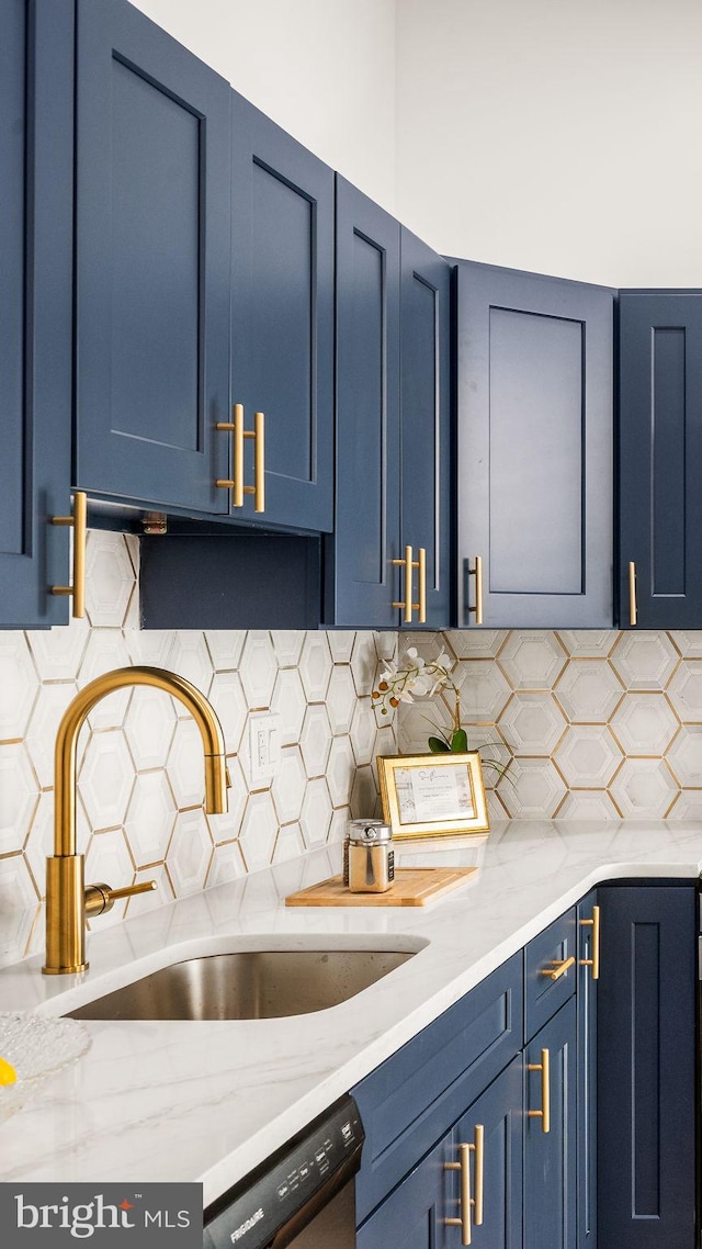 kitchen featuring a sink, tasteful backsplash, blue cabinetry, and dishwasher