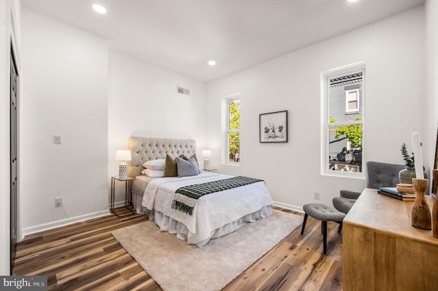 bedroom featuring baseboards, recessed lighting, wood finished floors, and visible vents