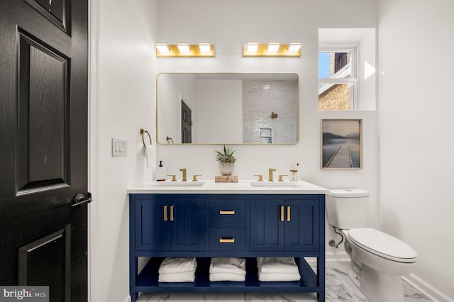 bathroom with toilet, baseboards, a sink, and marble finish floor