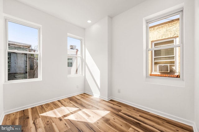 unfurnished room with baseboards, recessed lighting, wood finished floors, and cooling unit