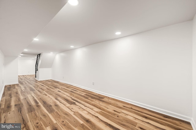 finished basement with baseboards, recessed lighting, and light wood-style flooring