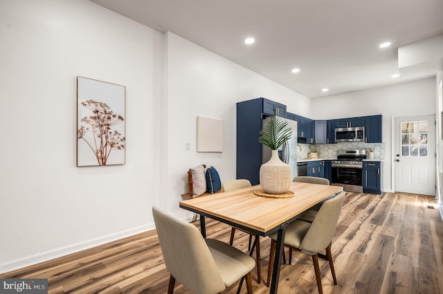 dining room with recessed lighting, baseboards, and light wood-type flooring