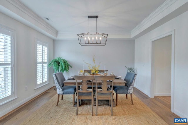 dining room featuring baseboards, an inviting chandelier, wood finished floors, and a raised ceiling