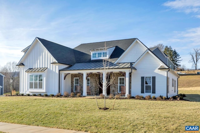 modern farmhouse with a standing seam roof, metal roof, a porch, and a front lawn