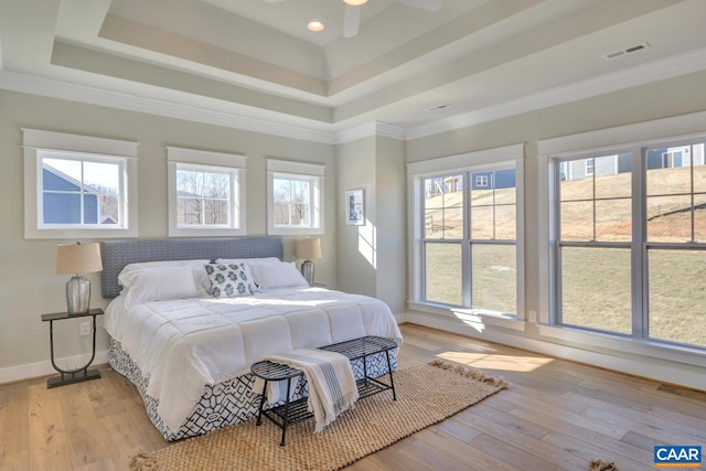 bedroom with visible vents, multiple windows, and a raised ceiling
