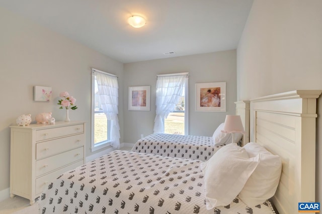 bedroom with baseboards and light carpet