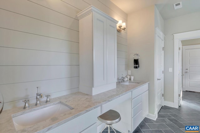 bathroom with double vanity, tile patterned floors, visible vents, and a sink