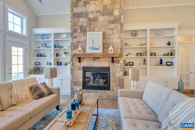 living area with a stone fireplace, wood ceiling, wood finished floors, and built in shelves