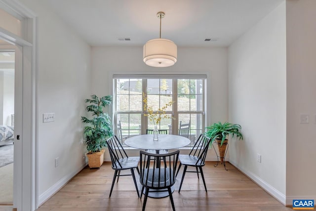 dining area with visible vents, baseboards, and light wood-type flooring