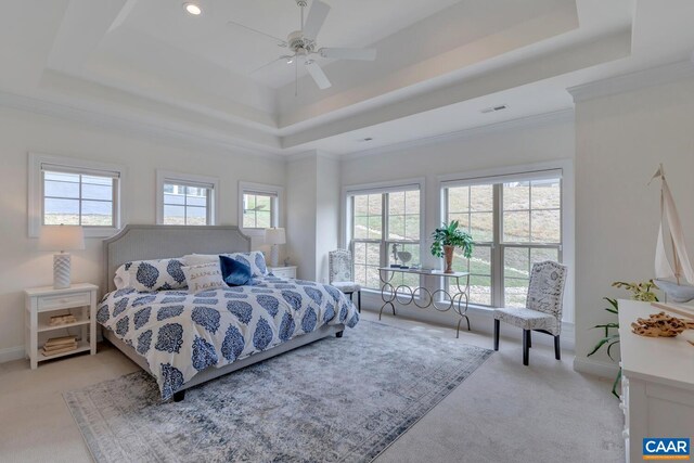 bedroom featuring baseboards, crown molding, a tray ceiling, and light carpet