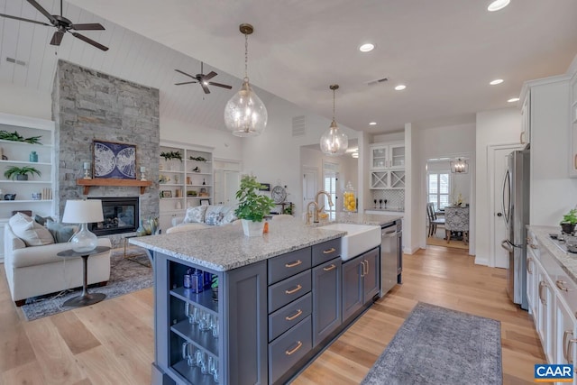 kitchen featuring ceiling fan, visible vents, appliances with stainless steel finishes, white cabinetry, and light wood-style flooring