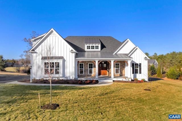 modern farmhouse with board and batten siding, covered porch, a standing seam roof, metal roof, and a front yard
